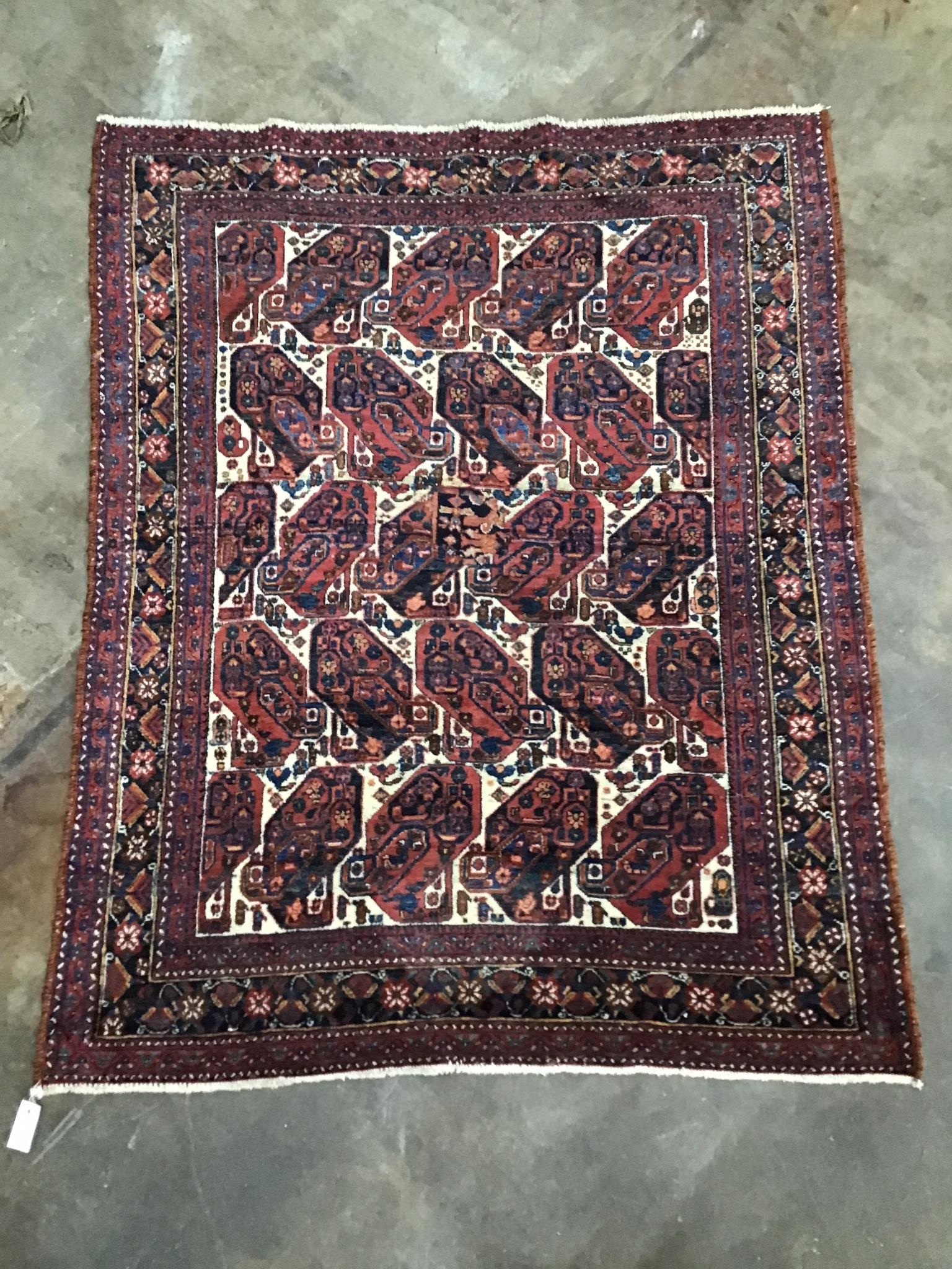 A Qashqai ivory ground rug woven with rows of stylised boteh, 170 x 136 cm